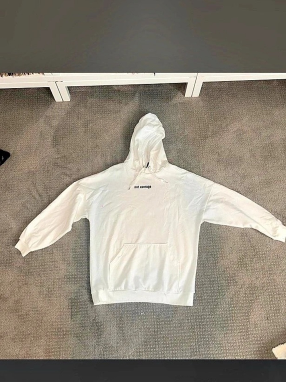 White hoodie (oversized) with black text reading 'not average'